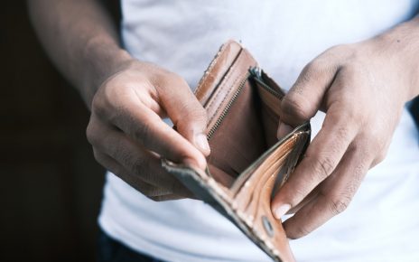 person holding brown leather bifold wallet